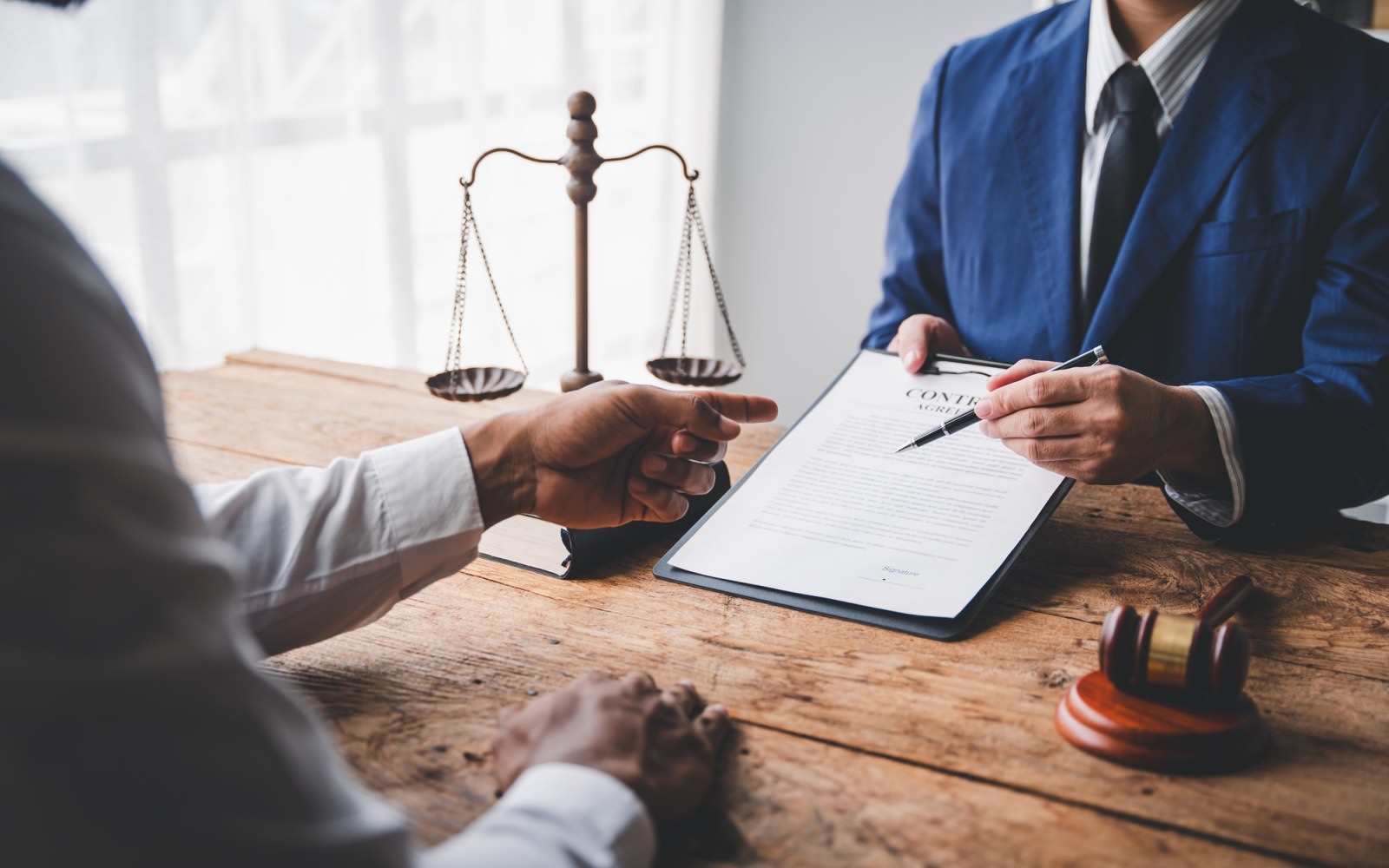 Two people sitting at a table going over a contract